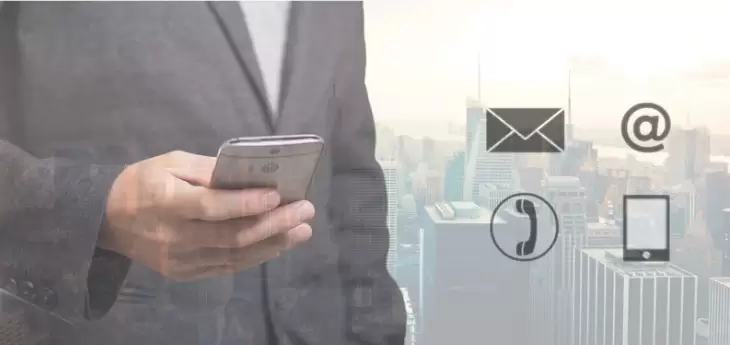 Contactez-nous par téléphone, email ou formulaire en lig Homme en costume tenant un smartphone avec des icônes de contact : téléphone, email, mob